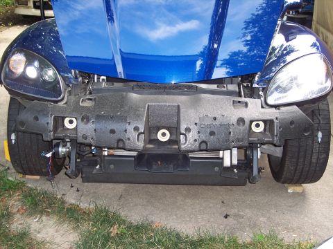 2006 Chevrolet Corvette - Front bumper assembly removed from a blue car, revealing internal components and mounting hardware.