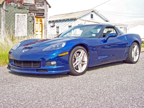 2006 Chevrolet Corvette - A blue Chevrolet Corvette is parked in front of some old buildings.