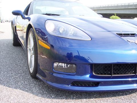 2006 Chevrolet Corvette - Front view of a blue 2006 Chevrolet Corvette, highlighting its distinctive bumper design with integrated fog lights and grille.