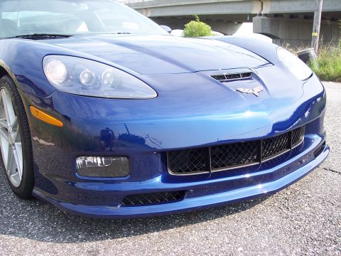 2006 Chevrolet Corvette - Close-up of the front grille and headlights of a blue Chevrolet Corvette.
