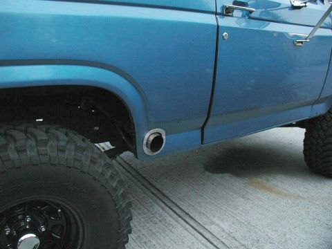 1985 Ford Bronco - This blue SUV has a side exhaust pipe exiting below the rear fender.