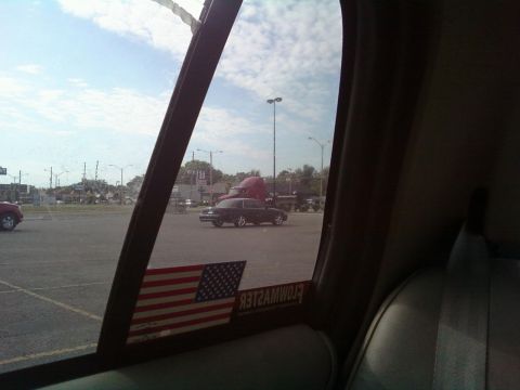 2000 Mercury Grand Marquis - Side view of a 2000 Mercury Grand Marquis in a parking lot, with a red semi-truck also visible.