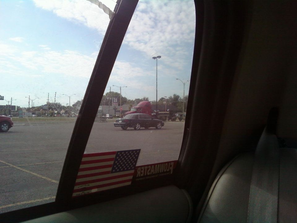 2000 Mercury Grand Marquis parked in a lot, seen from inside another vehicle. American flag sticker on the window