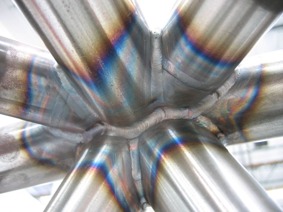 Close-up of iridescent welds on a metal structure