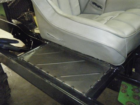 1978 Ford Bronco - Custom metal floor panel and gray bucket seat visible in a vehicle's interior.