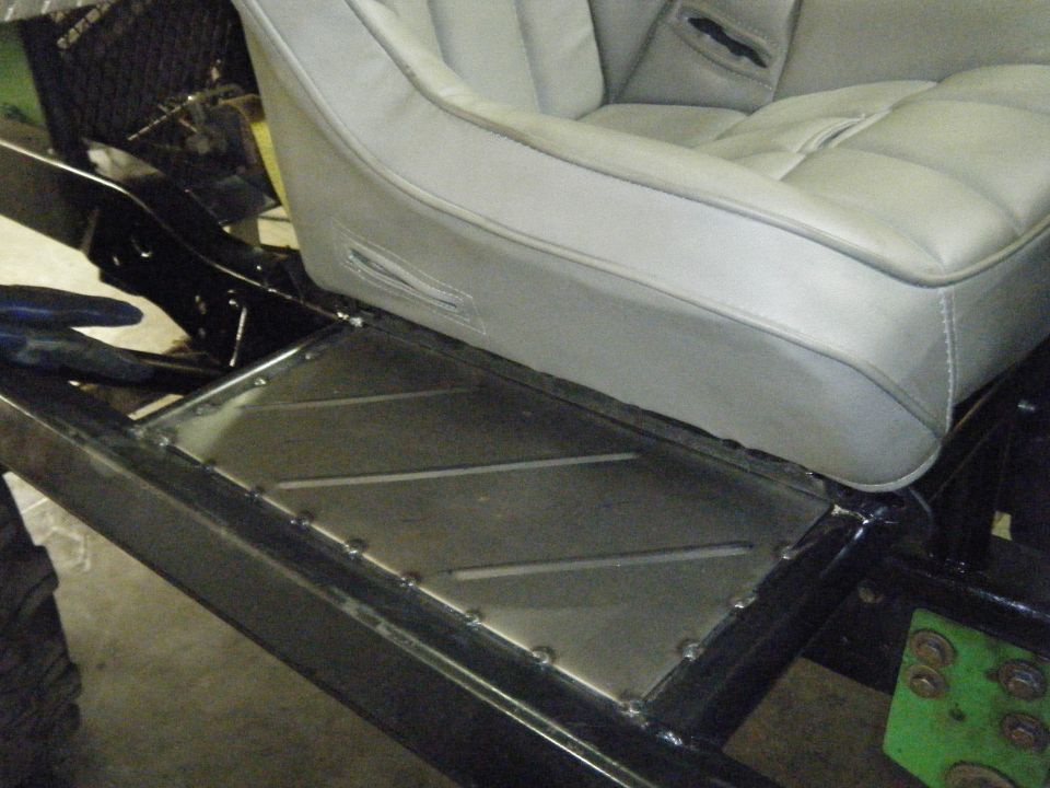 Vehicle interior with gray bucket seat and custom metal floor panel