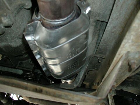 1985 Ford Bronco - Close-up of a vehicle's exhaust component, likely a catalytic converter, mounted underneath.
