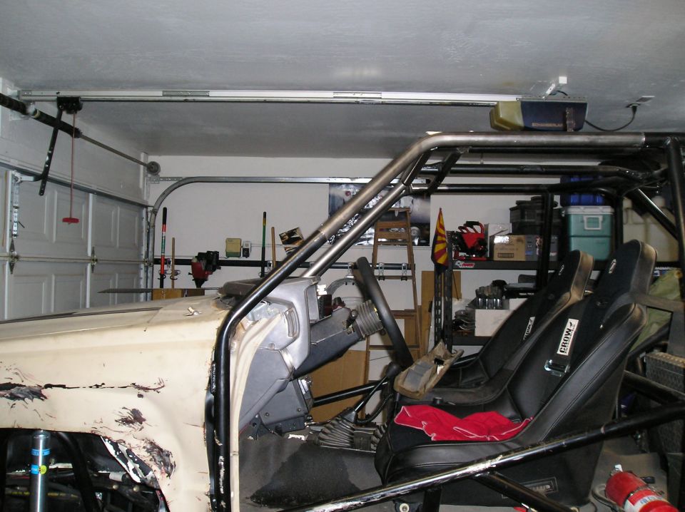 Interior of a modified pickup truck with racing seats, roll cage, and dashboard