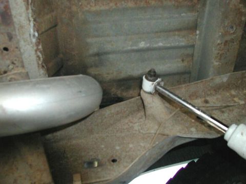 1985 Ford Bronco - Undercarriage view of an exhaust pipe and shock absorber mount, likely from an older vehicle.