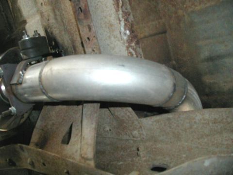 1985 Ford Bronco - A new exhaust pipe has been installed on the underside of a vehicle, contrasting with the aged frame.