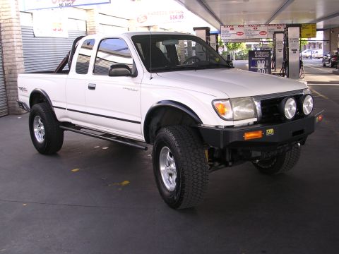 1999 Toyota Tacoma - This 1999 Toyota Tacoma is parked at a gas station with fuel pumps visible in the background.