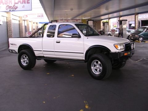 1999 Toyota Tacoma - This white Toyota pickup truck, likely from the mid-1990s, is parked under a covered area.