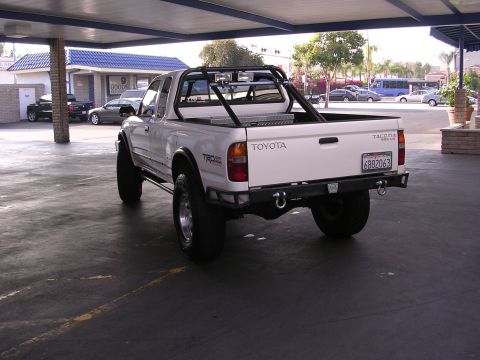 1999 Toyota Tacoma - White 1999 Toyota Tacoma TRD pickup truck with aftermarket modifications and a toolbox in the bed.