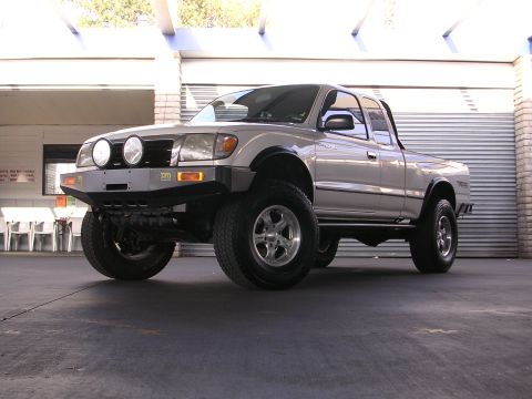 1999 Toyota Tacoma - This modified Toyota pickup truck has a custom bumper and large tires, suggesting it is not a 1999 model.