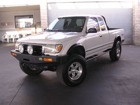 1999 Toyota Tacoma - This 1999 Toyota Tacoma is shown from a 3q-front angle, a white exterior and an aftermarket bumper with auxiliary lights.