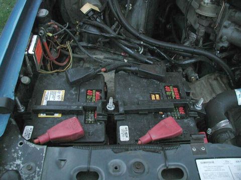1985 Ford Bronco - The engine bay shows two Magna 40 batteries with red terminal covers and various electrical connections.