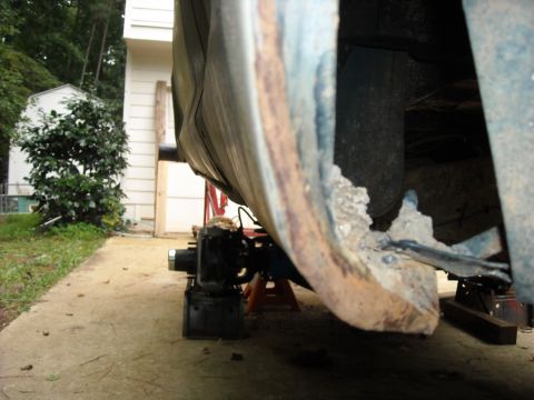 1979 Ford F-150 - Detail of a vehicle's undercarriage shows significant rust and damage to a metal panel.
