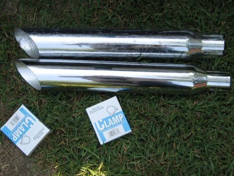 2000 Mercury Grand Marquis - Two chrome exhaust pipes and two boxes of clamps are displayed on a grassy surface.