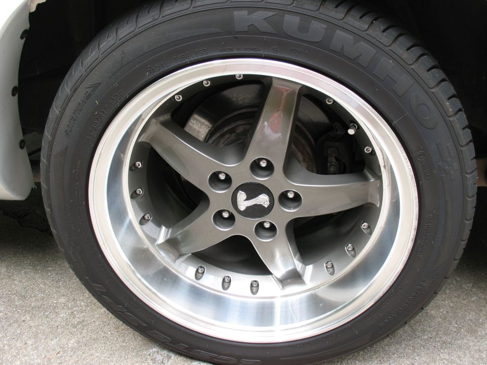 Five-spoke alloy wheel with Kumho tire mounted on a vehicle