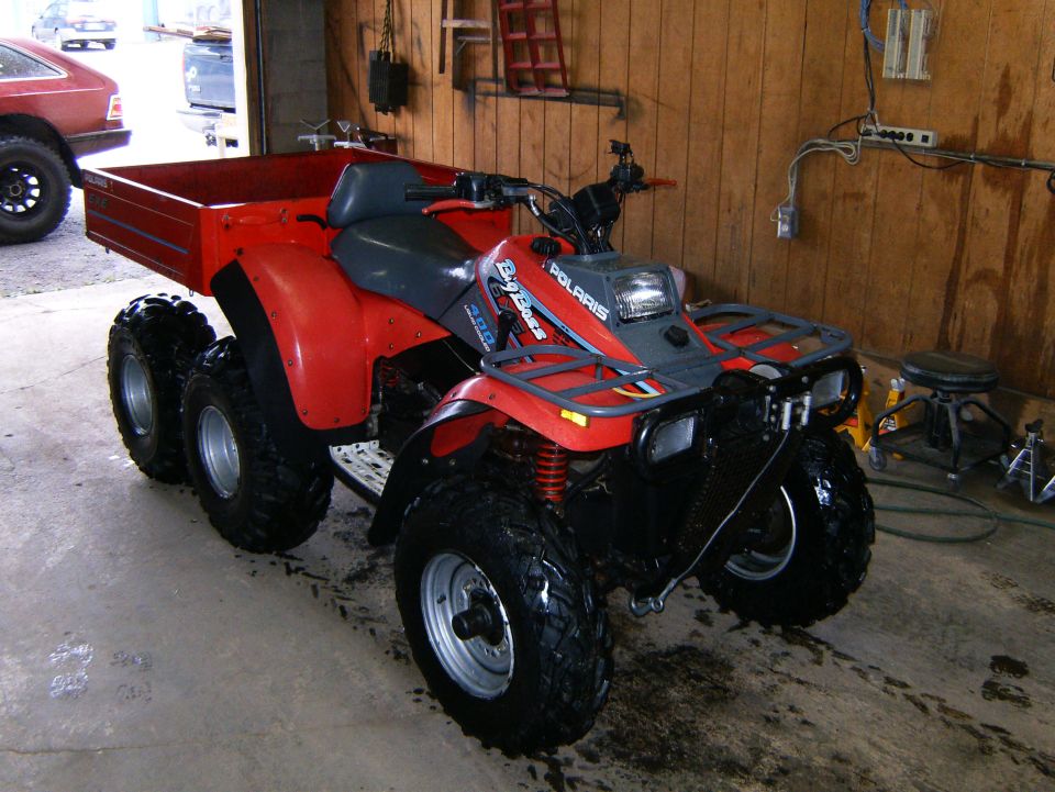 Red six-wheeled Polaris Big Boss ATV with cargo bed
