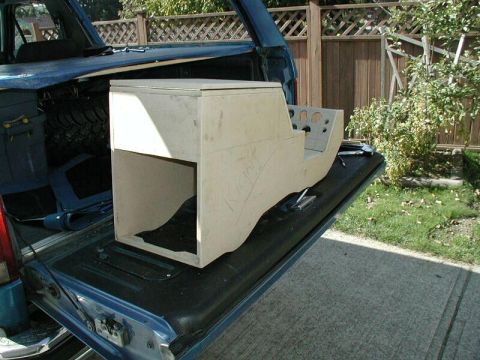 1985 Ford Bronco - Custom unfinished center console with multiple gauge openings sits in the bed of a blue pickup truck.