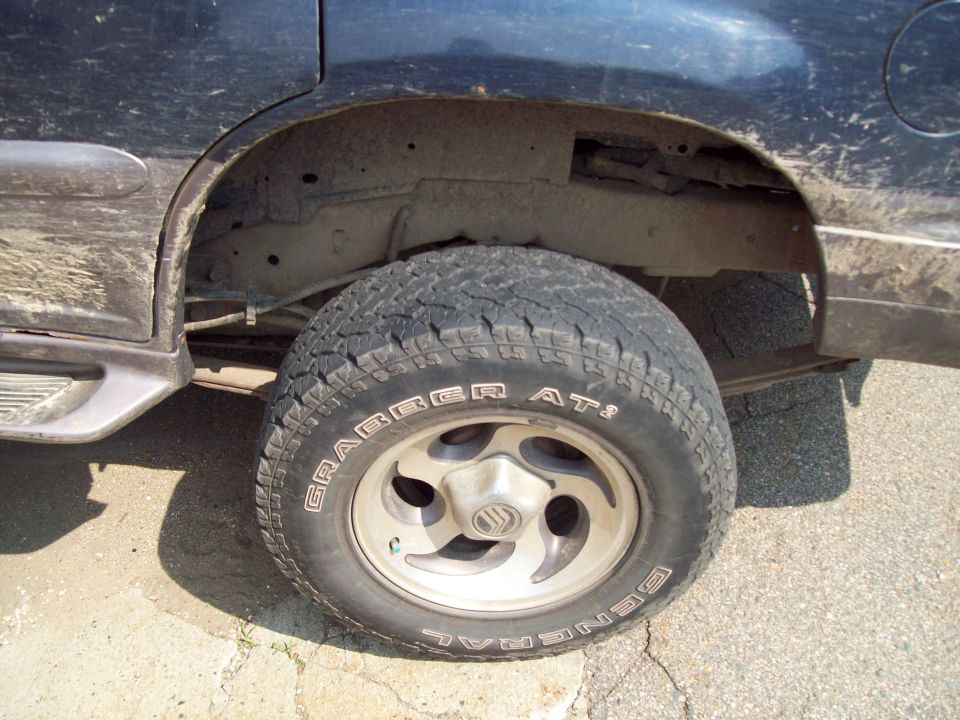 Rear wheel and fender area of a 1997 Mercury Mountaineer. Tire is a General Grabber AT2