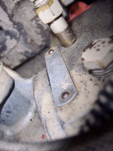 1981 Kenworth W900A - A stamped metal plate is riveted to a dirty engine part, showing some legible numbers.