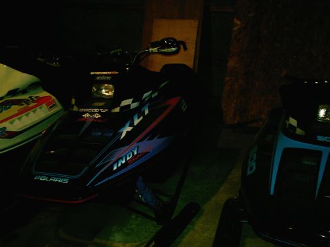 2001 Dodge 2500 - A black Polaris Indy XLT snowmobile is parked next to other snowmobiles.