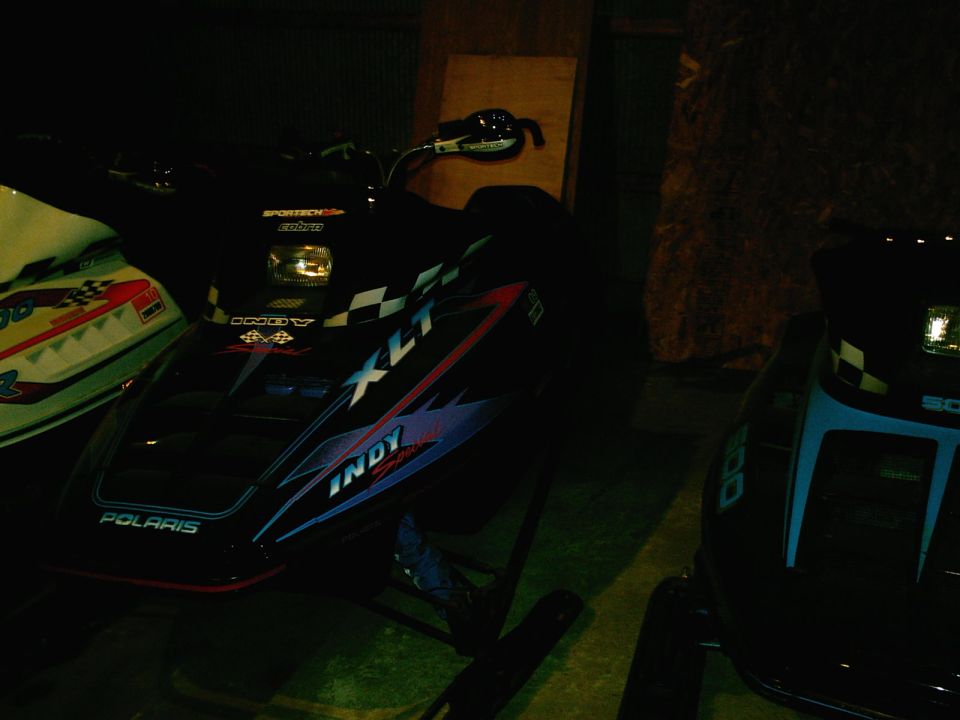 Black Polaris Indy XLT snowmobile with checkered flag graphics