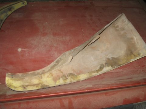 1979 Chevrolet Camaro - A damaged car fender section, possibly from a 1979 Chevrolet Camaro, is shown on a red surface.