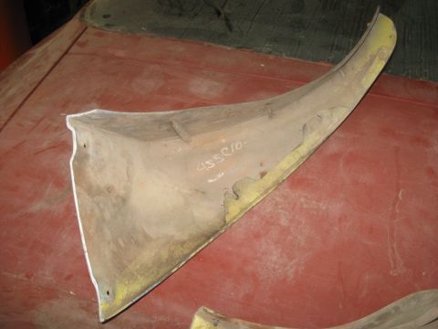 1979 Chevrolet Camaro - A close-up view of a detached car fender section with visible markings and paint.