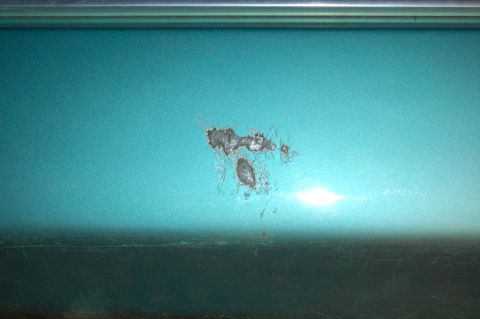 1994 Ford Bronco - A small patch of rust is visible on the teal-colored body of a vehicle.