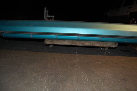 1994 Ford Bronco - A close-up view of a vehicle's door sill, supported by a roller mechanism.