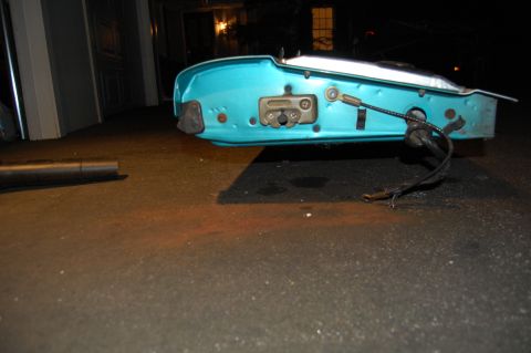 1994 Ford Bronco - Close-up of a detached turquoise car door's interior mechanism and wiring.