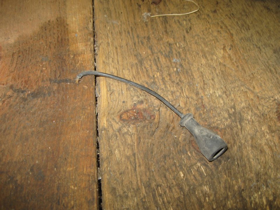 Spark plug wire with a black rubber boot on a wooden surface
