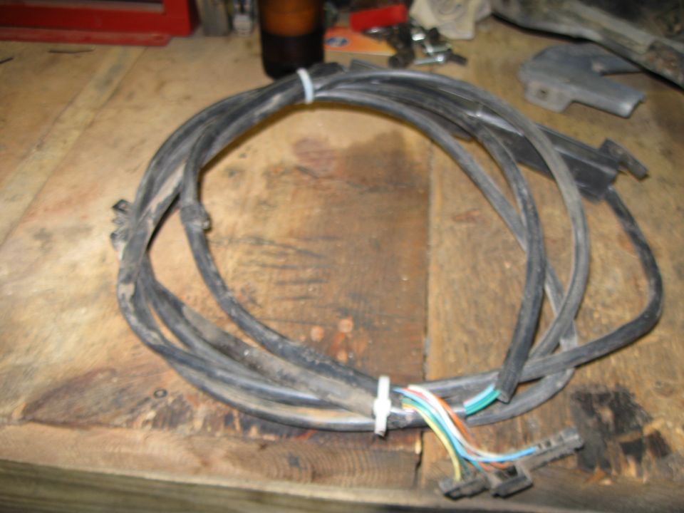 Bundle of black wires with colored wires showing at the end, tied with a white zip tie. Sitting on a wooden surface