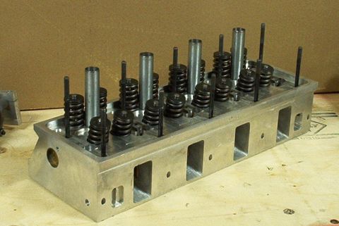 1972 Ford Ranchero - An aluminum engine cylinder head with multiple springs and valves is shown, resting on a wooden surface.