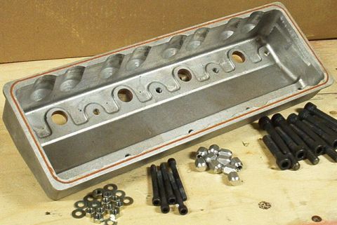 1972 Ford Ranchero - Engine valve cover and assorted hardware laid out on a workbench.