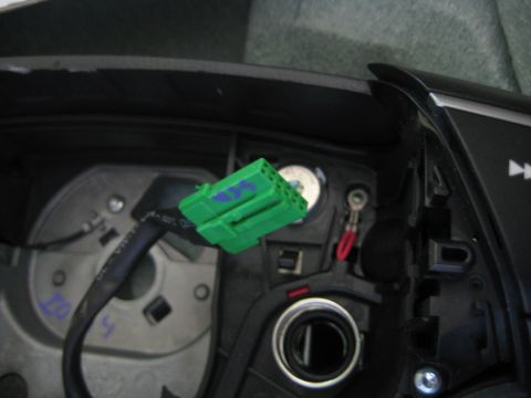 1993 Ford Probe - A close-up view of a green electrical connector with blue markings, attached to a vehicle's wiring.