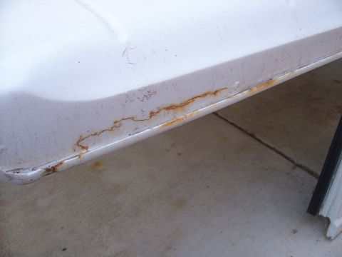 1970 Jeep Jeepster - Rust is visible along the bottom edge of a white vehicle's body panel.