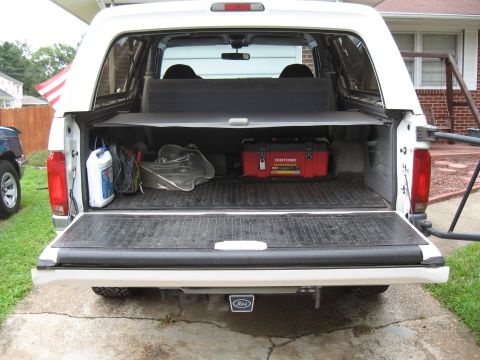 1994 Ford Bronco - Rear view of a 1994 Ford Bronco's cargo space, showing a toolbox and other items.