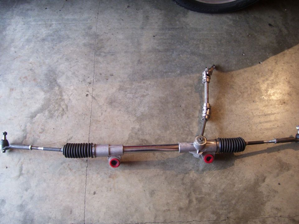 Steering rack and pinion assembly with red bushings and tie rod ends