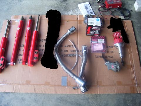 1990 Ford Mustang - Collection of automotive parts including shocks, fuel pump, and ignition distributor.