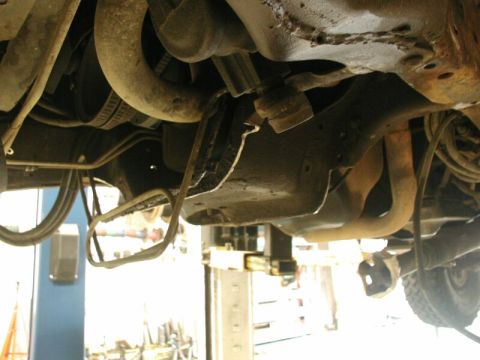 1985 Ford Bronco - The underside of a vehicle is shown, with various mechanical parts visible.