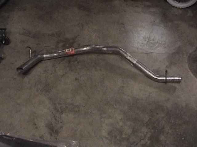 exhaust pipe on concrete floor, has red sticker