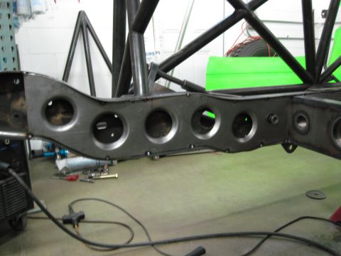 1995 Ford Bronco - Custom fabrication work on a vehicle frame and roll cage, showing structural components and circular cutouts.