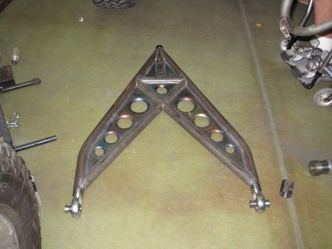 1995 Ford Bronco - A custom fabricated metal part, possibly for a vehicle suspension or frame, is shown on a workshop floor.