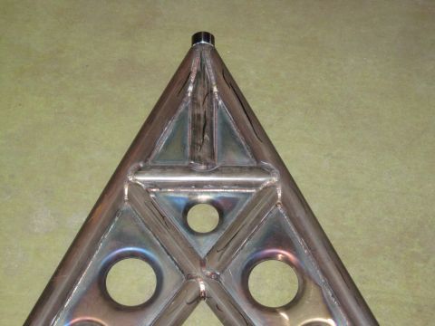 1995 Ford Bronco - Close-up of a custom fabricated triangular metal part, possibly for a tire carrier, with the Supermotors logo in the corner.