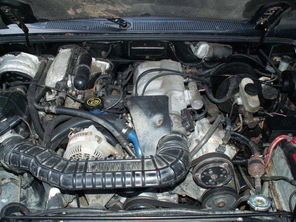 1994 Ford Ranger engine bay with V6 engine, air intake, alternator, and battery visible