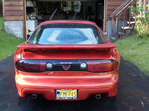 2001 Pontiac Trans Am - Rear view of a red 2001 Pontiac Trans Am parked in front of a garage.